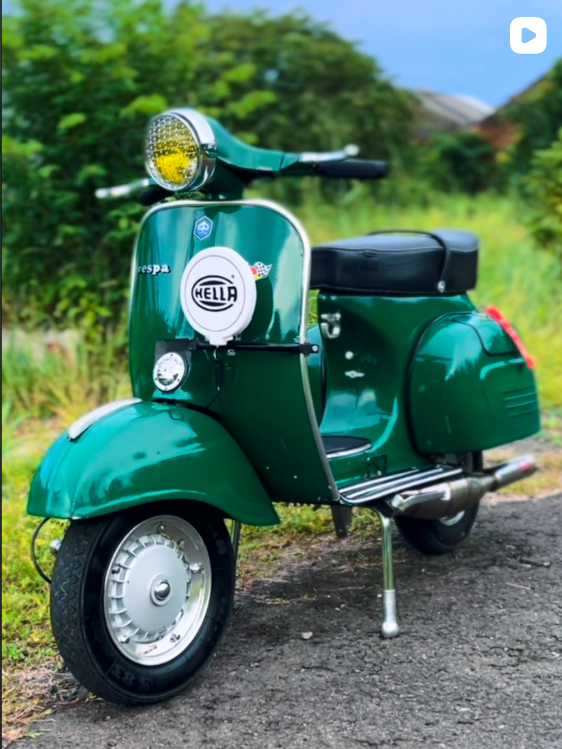 Vespa hijau emerald dengan lampu kuning dan aksesori Hella
